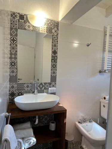 uma casa de banho com um lavatório, um espelho e um WC. em TOWER Adults only em Villa General Belgrano