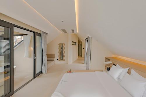 a bedroom with a white bed and a large window at Dali Oriental Seaview Hotel -Dali Erhai in Dali