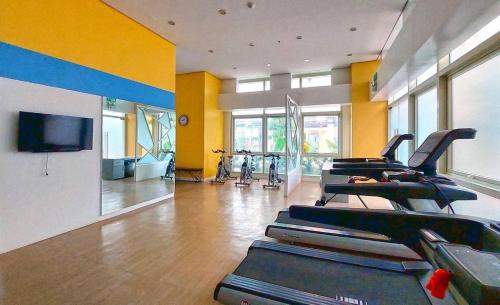 a gym with a bunch of treadmills in a room at Neat Unit in Holland Park Southwoods in Biñan