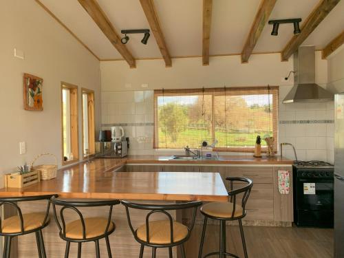 a kitchen with a table and chairs in it at Cabaña Familiar de Descanso y Paseo - Puyehue in Puyehue