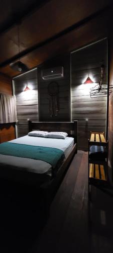 a bedroom with a large bed and a mirror at Morooka ÁGUA chalé com hidromassagem ALTER CHÃO in Alter do Chao