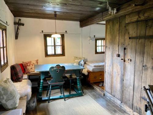 a living room with a table and a bed at Kastnhäusl Wildschönau - urige Hütte mit Bergblick in Oberau