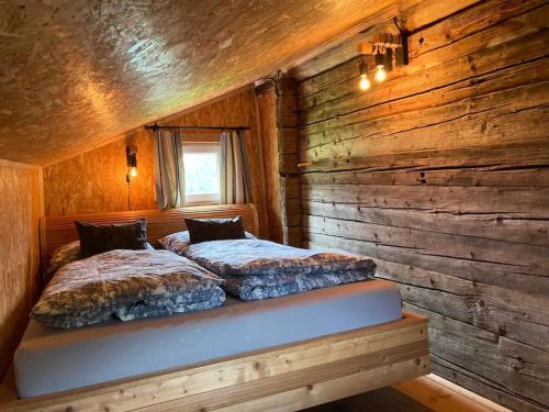 Un pat sau paturi într-o cameră la Kastnhäusl Wildschönau - urige Hütte mit Bergblick