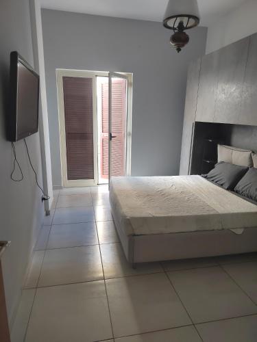 Schlafzimmer mit einem Bett und einem Flachbild-TV in der Unterkunft Tranquillo ed economico in Calvizzano