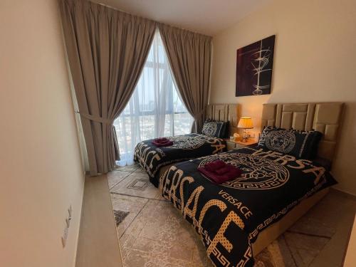 a hotel room with two beds and a window at Holiday Homes Amazing 2 Bedroom City Skyline View in Ajman 