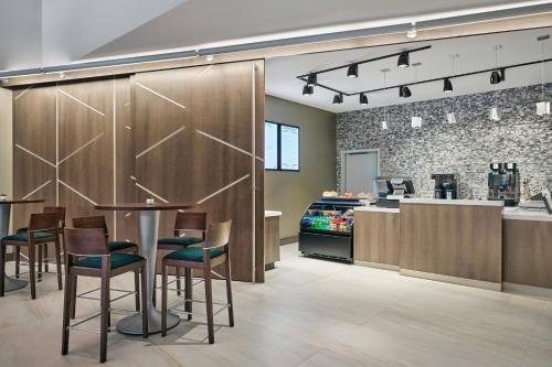 a restaurant with a bar with chairs and a counter at Delta Hotels by Marriott Ashland Downtown in Ashland