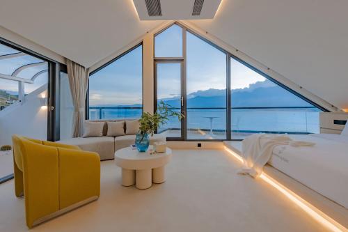 a living room with large windows and a couch and a table at Dali Oriental Seaview Hotel -Dali Erhai in Dali