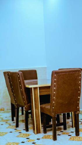 a dining room table with two chairs and a wooden table at Select Elegant 3 Rooms 3 sized king-bed @ Abuja FCT in Abuja