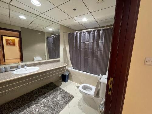 a bathroom with a sink and a toilet and a mirror at Holiday Homes Amazing 2 Bedroom City Skyline View in Ajman 