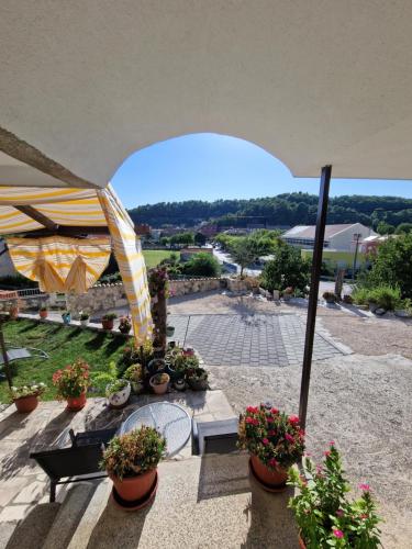 a patio with a table and flowers and an umbrella at Rooms Marijeta in Skradin