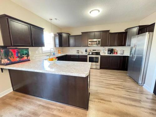 a kitchen with wooden cabinets and a counter top at Beautiful home with Viking Royale Spa conveniently located near the Marines in Jacksonville