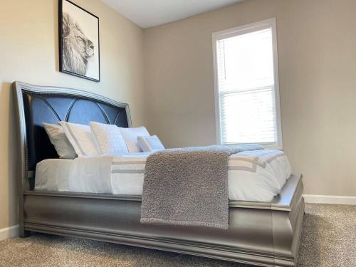 a bedroom with a bed with a black frame and a window at Beautiful home with Viking Royale Spa conveniently located near the Marines in Jacksonville