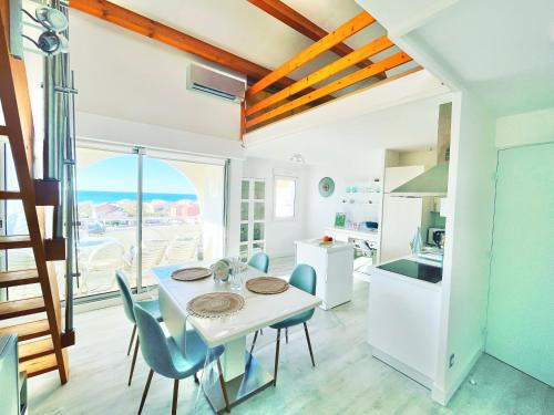 una cucina e una sala da pranzo con tavolo e sedie di La Sirène - Loft moderne et lumineux avec vue panoramique sur Mer Méditerranée et port de plaisance a Frontignan