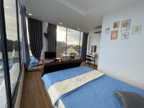 a bedroom with a blue bed and a large window at Ngoc An Hotel in Tây Ninh