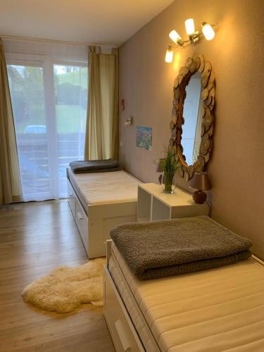 a bedroom with two beds and a mirror on the wall at Ferienwohnung Oberstdorf in Oberstdorf