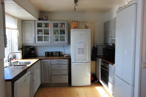 una cucina con armadietti bianchi e frigorifero bianco di Bamse a Bodø