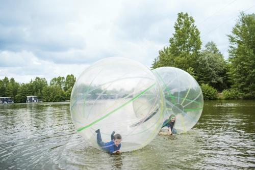 two children in inflatable spheres in the water at Center Parcs Bispinger Lüneburger Heide in Bispingen
