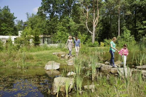 a group of people walking around a pond in a garden at Center Parcs Bispinger Lüneburger Heide in Bispingen