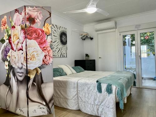 a bedroom with a bed and flowers on the wall at Loft JUNTO AL MAR in Vinaròs