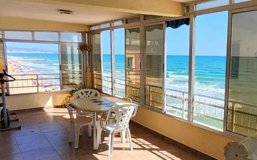 ein Esszimmer mit Tisch und Stühlen und dem Meer in der Unterkunft Tavernes de Valldigna Chez Svetlana in El Brosquil