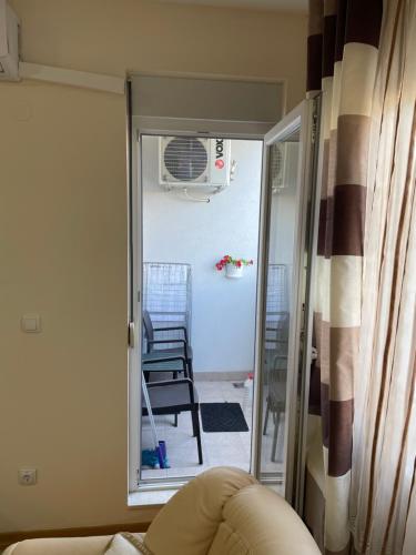 ein Wohnzimmer mit einer Tür, die auf eine Terrasse führt in der Unterkunft Gordana Apartments in Belgrad