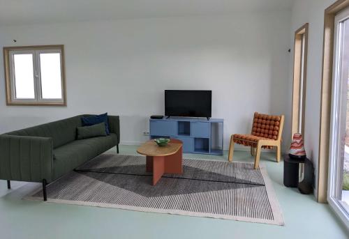 un soggiorno con divano, TV e sedia di Modern and spacious Cork House with private valley view a Caldas da Rainha