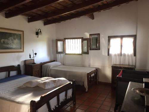 a bedroom with two beds and two windows at Campo Las Marias in Santa Catalina