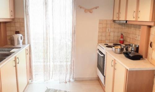 een keuken met witte kasten en een fornuis met oven bij 6 pax Glyfada 2floor apartment in Athene