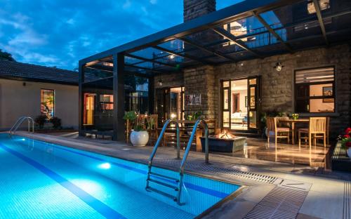 a swimming pool in front of a house at Deerpark Luxury Stays in Nairobi