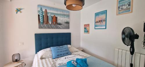 a bedroom with a bed with a blue head board at HOME ET HOLIDAY Le Chardonnay in La Baule