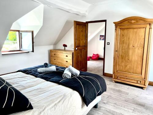 - une chambre avec un grand lit et une commode en bois dans l'établissement Gîte Diamant, Vallée du Scorff, Nature, Bien-être, à Arzano