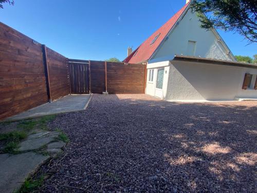 uma casa com uma cerca de madeira e uma entrada em La Foulnerie Studio avec cour autonome 61270 Rai proche 61300 l'Aigle 