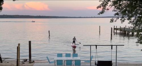 a person on a paddle board in the water at Waterfront Home with Private Beach, Stunning Views in Middle River