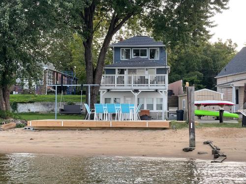 a house with chairs on a dock next to the water at Waterfront Home with Private Beach, Stunning Views in Middle River