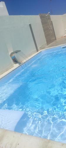 a swimming pool with blue water in it at Djerba La Douce in Houmt Souk