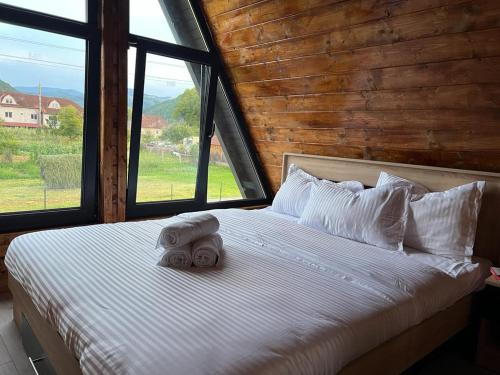 - une chambre avec un lit et des serviettes dans l'établissement Little House Bologa, à Bologa