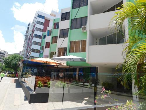 a building with an outdoor patio with an umbrella at El Velero Apartamentos By DANP in Santa Marta