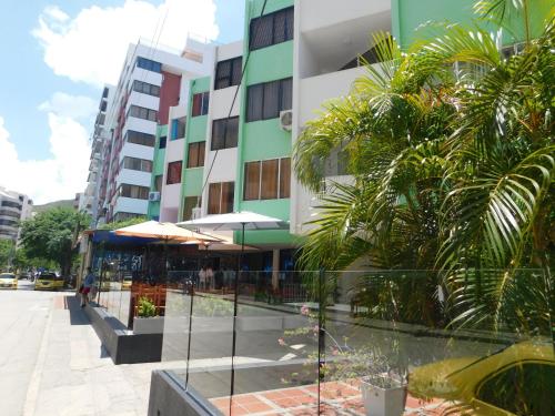 a view of a building with palm trees in front of it at El Velero Apartamentos By DANP in Santa Marta