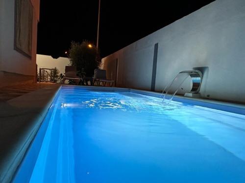 a swimming pool at night with a water fountain at Djerba La Douce in Houmt Souk
