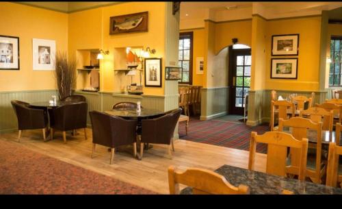 a restaurant with yellow walls and tables and chairs at Kilconquhar castle estate villa 6, 4 bed sleeps 10 in Fife