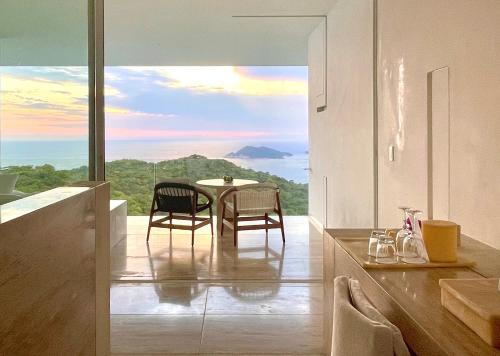a kitchen with a table and chairs and a view at Encanto Acapulco in Acapulco