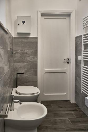 a bathroom with a toilet and a sink and a door at Eureka Room & Breakfast in Pietrapertosa
