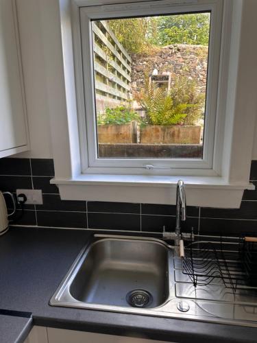 a kitchen sink with a window above it at Castle Brae Apartment in Stirling