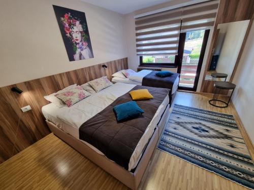 a bedroom with two beds and a large window at Olimpijada 84 Pale in Pale