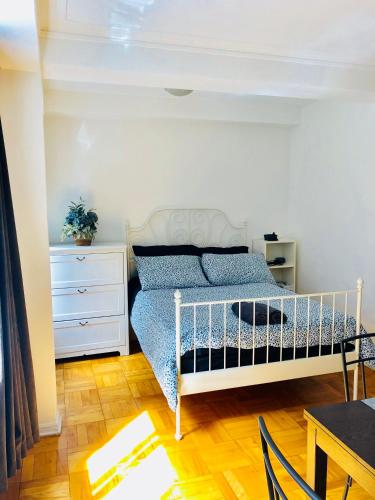 - une chambre avec un lit, une commode et une table dans l'établissement Stylish Montreal Apartment: Comfortable Stay in the Golden Square Mile, à Montréal