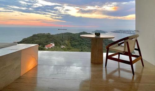 a table and a chair in a room with a view at Encanto Acapulco in Acapulco