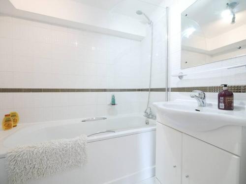 Baño blanco con bañera y lavamanos en Chelsea Cloisters en Londres
