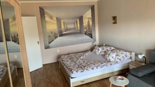 um quarto com uma cama com um quadro na parede em Sweet-home erkélyes apartman Kaposvár em Kaposvár