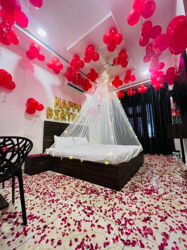 a bedroom with a bed with red hearts and balloons at Hotel Homeland Inn in Sirsa