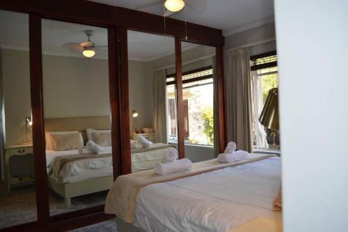 a bedroom with two beds and a large mirror at Serendipity - Home in Die Boord, Stellenbosch & solar power! in Stellenbosch
